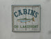 Cabins on Lakefront with Painted Fish White with Blue Trim Americana Art